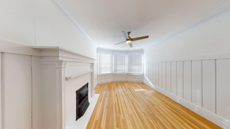 A long hallway with wood floors and white walls.